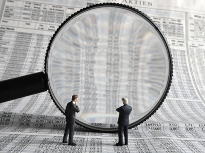 Businessmen looking through giant spy glass