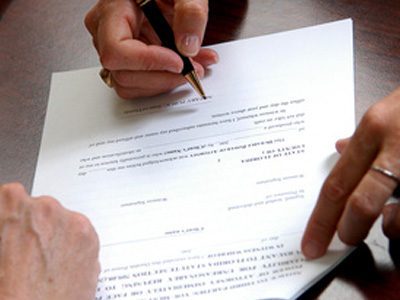 Person with pen going over paperwork